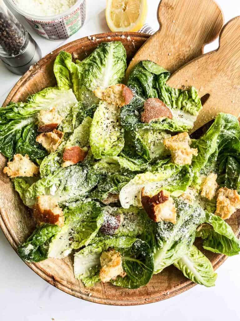 Cacio e Pepe Salad with salad tongs.